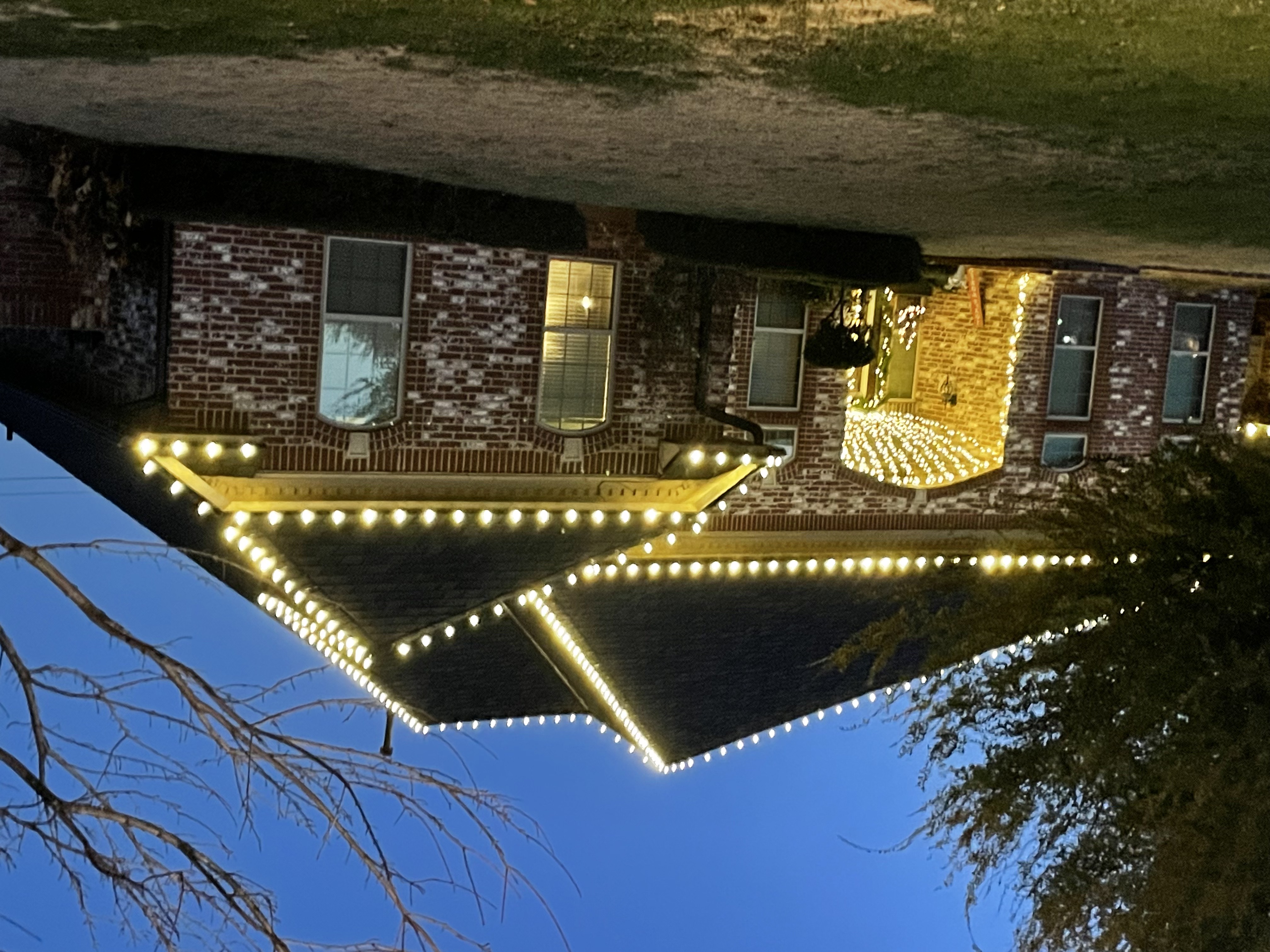 Christmas light installation featuring classic white lights along roofline and porch area of Oklahoma City home