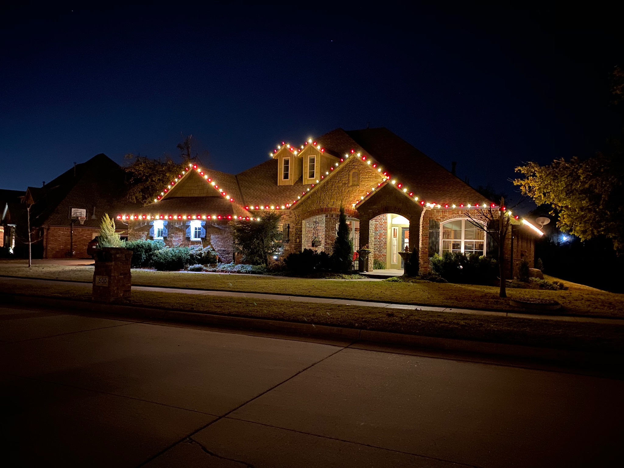 Red and white Christmas lights roofline installation exemplifying our festive work in Norman, Oklahoma